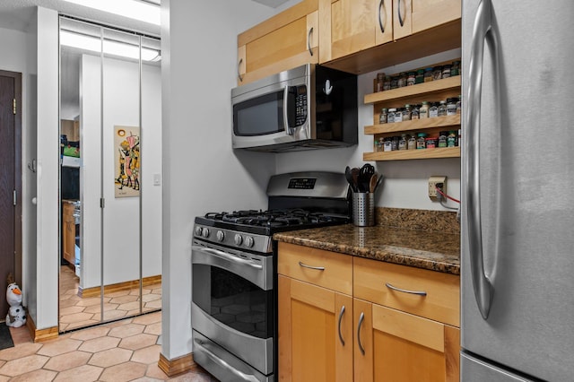 333 8th St SE Unit 120, Minneapolis, MN 55414 - kitchen with stainless steel appliances, light tile patterned flooring, open shelves, and dark stone countertops