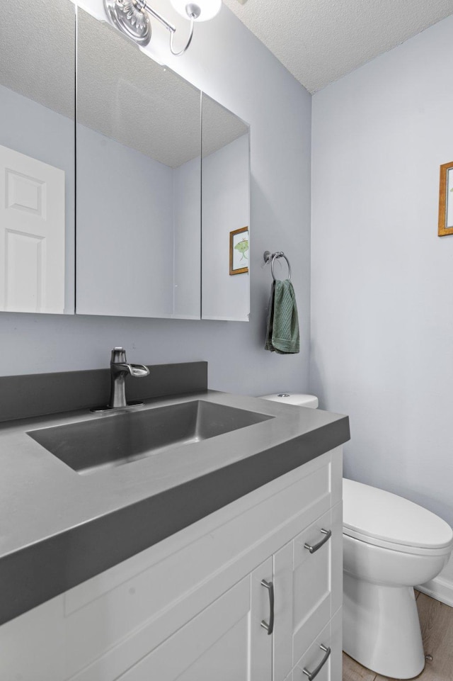 333 8th St SE Unit 120, Minneapolis, MN 55414 - bathroom featuring vanity, a textured ceiling, and wood finished floors
