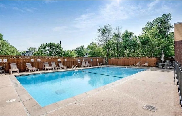 333 8th St SE Unit 120, Minneapolis, MN 55414 - community pool featuring a patio and view of wooded area