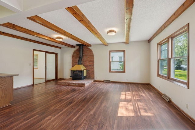 7507 Blaisdell Ave, Richfield, MN 55423 - unfurnished living room with a wood stove, wood finished floors, beam ceiling, and a textured ceiling