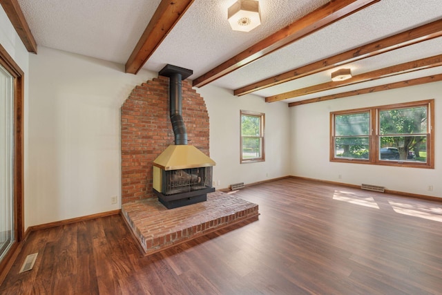 7507 Blaisdell Ave, Richfield, MN 55423 - unfurnished living room with a textured ceiling, a wood stove, wood finished floors, and beamed ceiling
