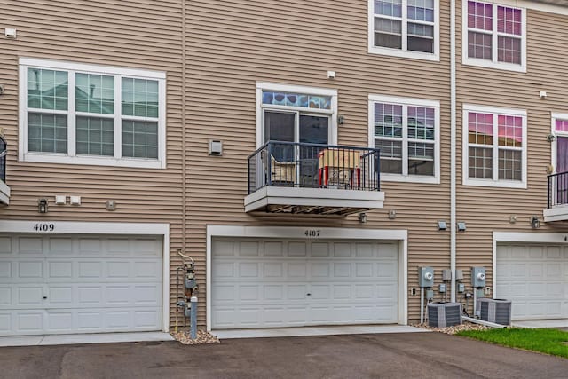 4107 Scott Ave N, Robbinsdale, MN 55422 - rear view of house with driveway, an attached garage, and a balcony