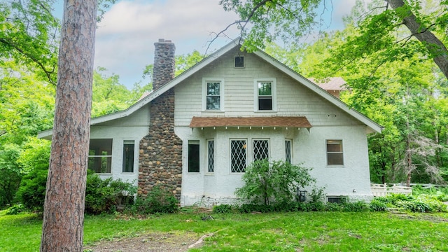 3672 Snelling Ave N, Arden Hills, MN 55112 - view of side of property featuring a chimney, stucco siding, a shingled roof, and a lawn