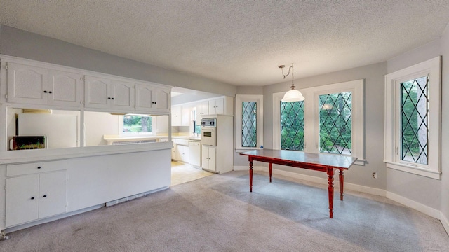 3672 Snelling Ave N, Arden Hills, MN 55112 - kitchen featuring white cabinets, a peninsula, light colored carpet, white appliances, and a textured ceiling