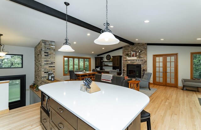 25 Conway Ct SE, Rochester Twp, MN 55904 - kitchen featuring a brick fireplace, plenty of natural light, light wood finished floors, and a kitchen island
