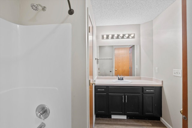 25634 3rd St W, Zimmerman, MN 55398 - bathroom with vanity, bathing tub / shower combination, wood finished floors, and a textured ceiling