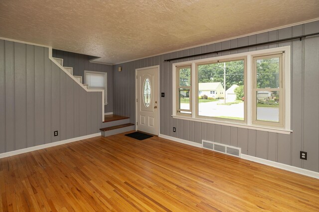 2010 Oakland Ave, Austin, MN 55912 - foyer featuring a textured ceiling, wood finished floors, ornamental molding, stairs, and wooden walls