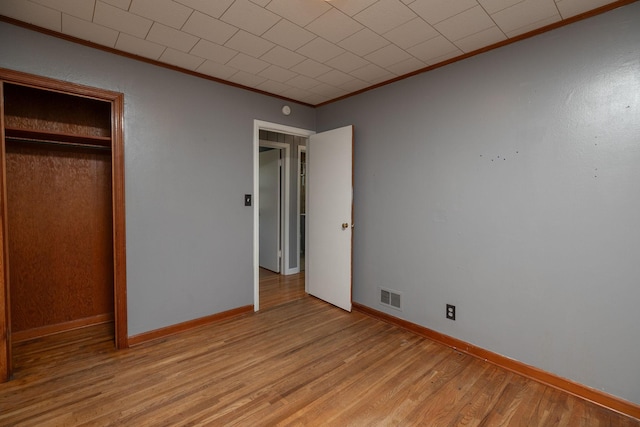 2010 Oakland Ave, Austin, MN 55912 - unfurnished bedroom featuring ornamental molding, light wood-style flooring, and a closet
