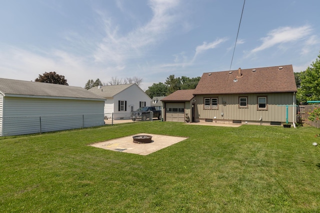 2010 Oakland Ave, Austin, MN 55912 - rear view of house with an outdoor fire pit, a patio, a garage, board and batten siding, and a shingled roof