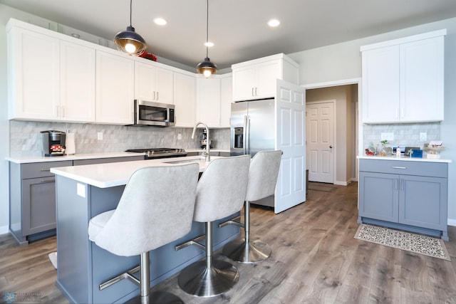 1326 Commander Dr W, West Fargo, ND 58078 - kitchen featuring stainless steel appliances, decorative backsplash, light countertops, recessed lighting, and a kitchen breakfast bar