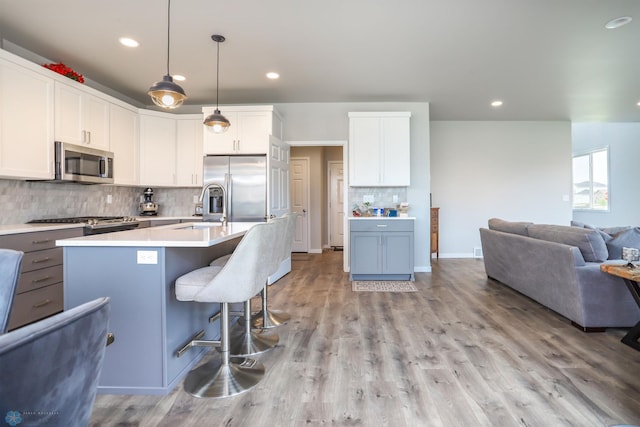 1326 Commander Dr W, West Fargo, ND 58078 - kitchen featuring stainless steel appliances, decorative backsplash, light countertops, open floor plan, and recessed lighting