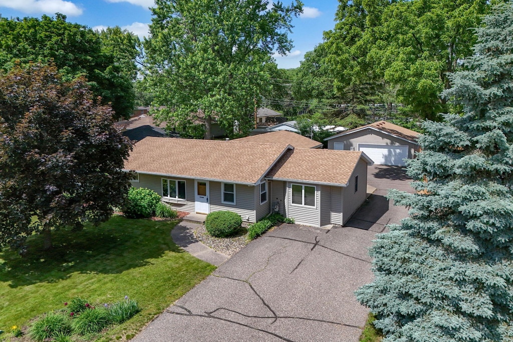 1620 Oak St, Hastings, MN 55033 - view of front of property featuring a front yard, a garage, roof with shingles, and a porch
