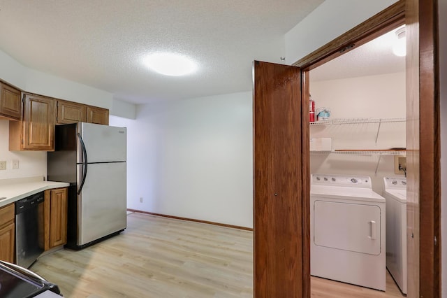 3801 98th St Unit 108, Bloomington, MN 55431 - kitchen with freestanding refrigerator, dishwashing machine, light wood-style floors, washer and dryer, and a textured ceiling