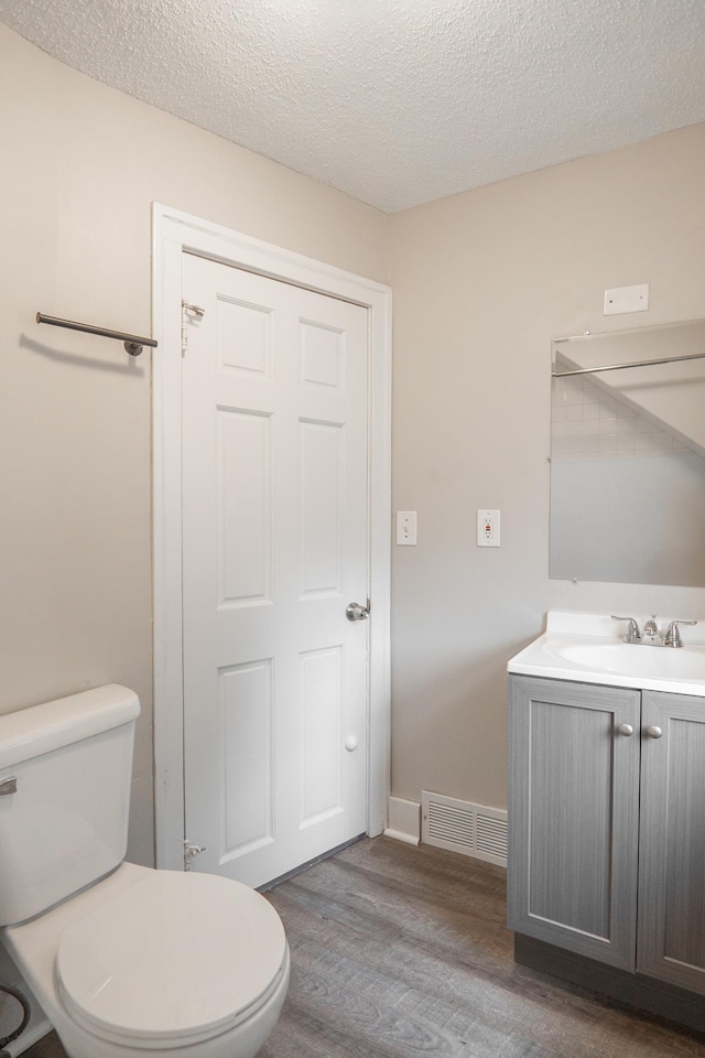 1303 Fremont Ave, Saint Paul, MN 55106 - bathroom featuring wood finished floors, vanity, and a textured ceiling