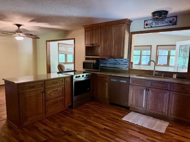 20430 Rhoda Ave, Ravenna Twp, MN 55089 - kitchen featuring stainless steel appliances, a peninsula, dark wood-type flooring, healthy amount of natural light, and a textured ceiling