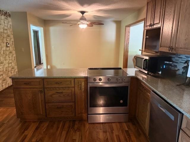 20430 Rhoda Ave, Ravenna Twp, MN 55089 - kitchen featuring stainless steel appliances, ceiling fan, dark wood finished floors, a peninsula, and a textured ceiling
