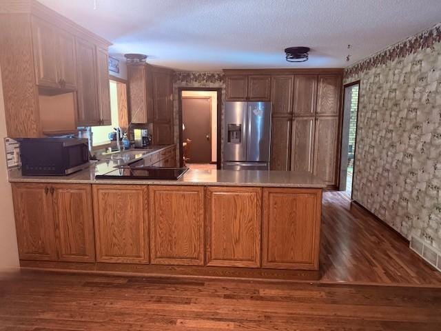 20430 Rhoda Ave, Ravenna Twp, MN 55089 - kitchen featuring stainless steel fridge with ice dispenser, black electric cooktop, a peninsula, wallpapered walls, and dark wood-type flooring