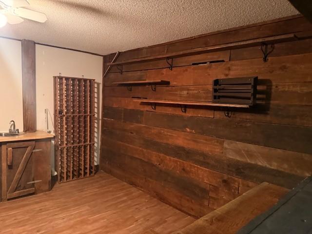 20430 Rhoda Ave, Ravenna Twp, MN 55089 - wine room featuring wooden walls, a textured ceiling, and wood finished floors