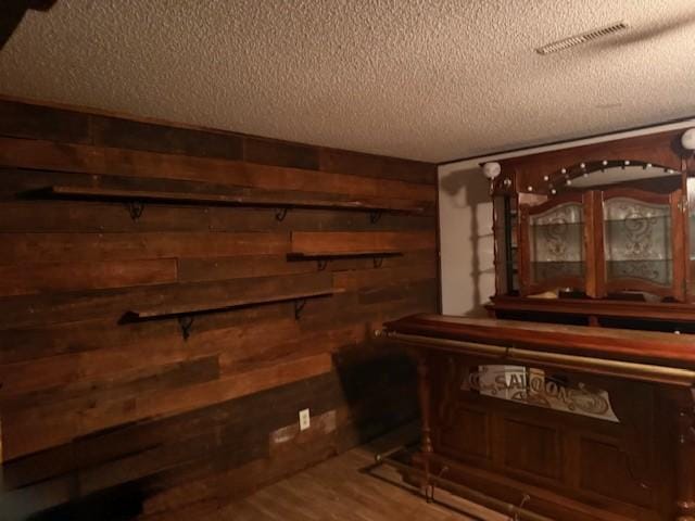 20430 Rhoda Ave, Ravenna Twp, MN 55089 - bar area featuring a textured ceiling, wooden walls, and wood finished floors