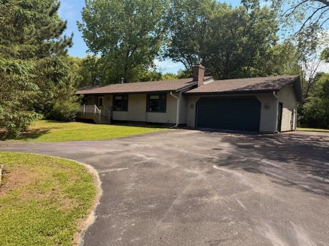 20430 Rhoda Ave, Ravenna Twp, MN 55089 - ranch-style house with driveway, a garage, a chimney, and a front lawn