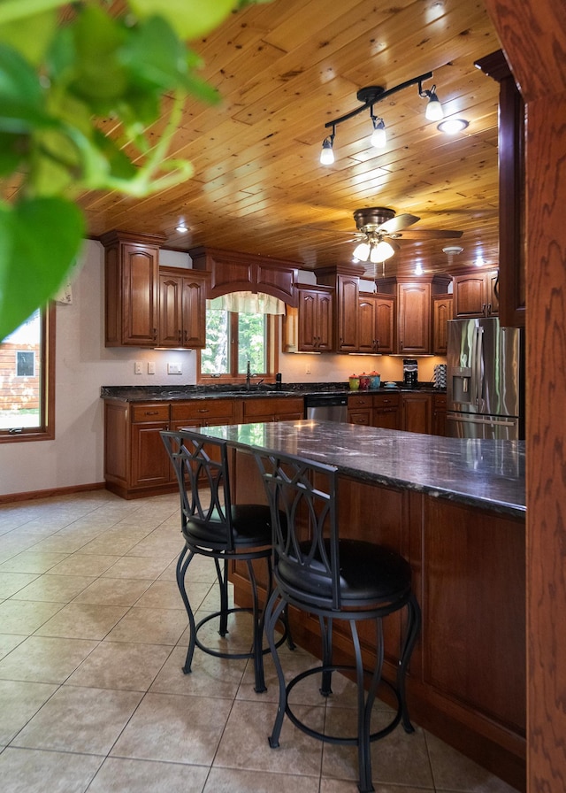 9777 Gruhlke Rd, Summit Twp, WI 54836 - kitchen featuring stainless steel appliances, wooden ceiling, a kitchen bar, light tile patterned flooring, and a ceiling fan