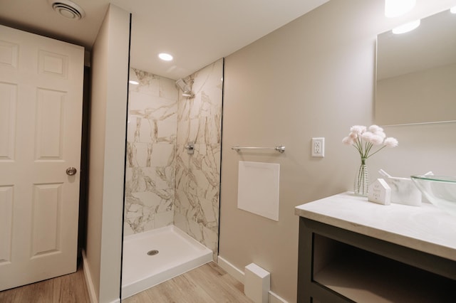 3445 4th Ave S, Minneapolis, MN 55408 - bathroom featuring vanity, a marble finish shower, wood finished floors, and recessed lighting