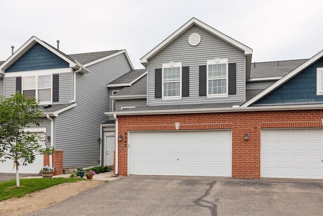 8547 Grove Cir, Shakopee, MN 55379 - view of front of house featuring roof with shingles, brick siding, and driveway