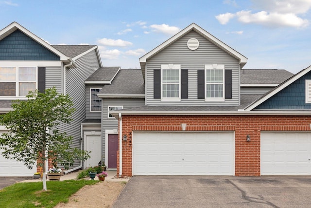 8547 Grove Cir, Shakopee, MN 55379 - view of front of home featuring a shingled roof, driveway, and brick siding
