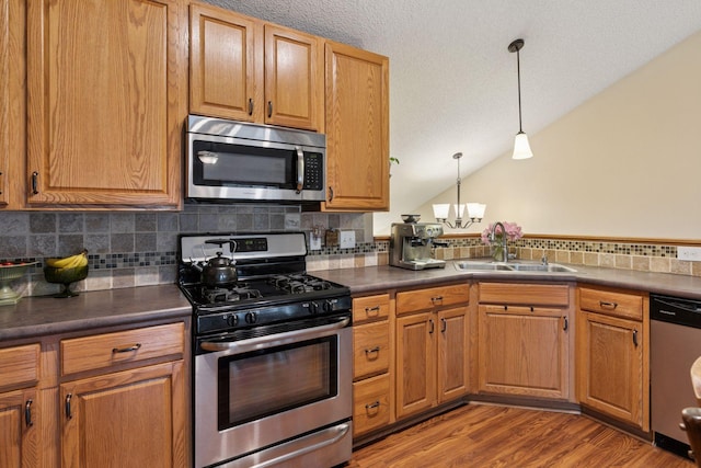 8547 Grove Cir, Shakopee, MN 55379 - kitchen with appliances with stainless steel finishes, dark countertops, backsplash, a chandelier, and vaulted ceiling