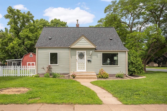333 3rd St NE, Osseo, MN 55369 - view of front of home with roof with shingles, a chimney, and a storage shed