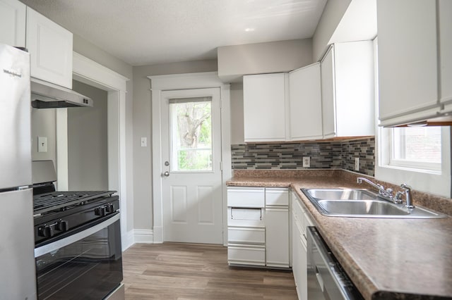 938 Cypress St, Saint Paul, MN 55106 - kitchen featuring stainless steel appliances, extractor fan, white cabinets, and wood finished floors
