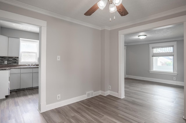 938 Cypress St, Saint Paul, MN 55106 - unfurnished room featuring a ceiling fan, wood finished floors, ornamental molding, and a textured ceiling