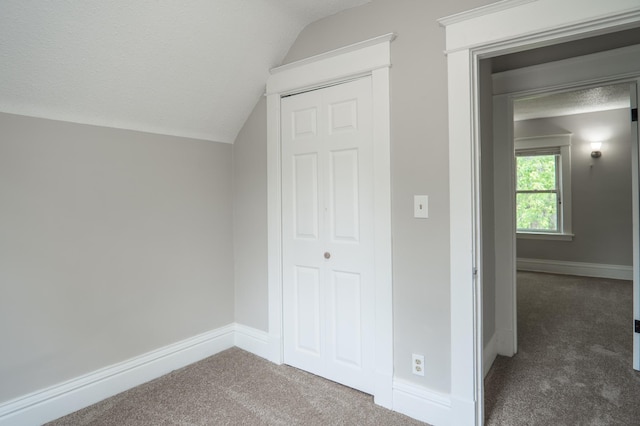 938 Cypress St, Saint Paul, MN 55106 - bonus room with dark carpet, vaulted ceiling, and a textured ceiling