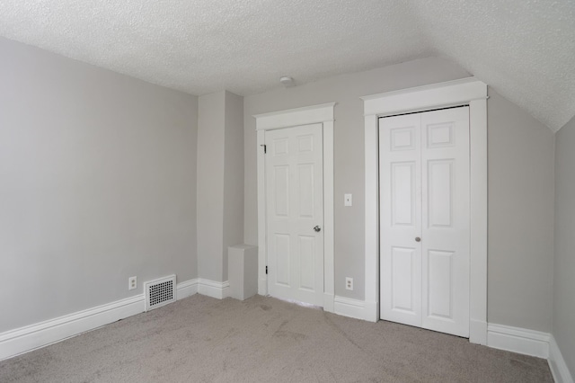 938 Cypress St, Saint Paul, MN 55106 - unfurnished bedroom with a textured ceiling, carpet flooring, a closet, and lofted ceiling