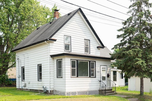 938 Cypress St, Saint Paul, MN 55106 - back of property with entry steps, roof with shingles, a chimney, and a yard