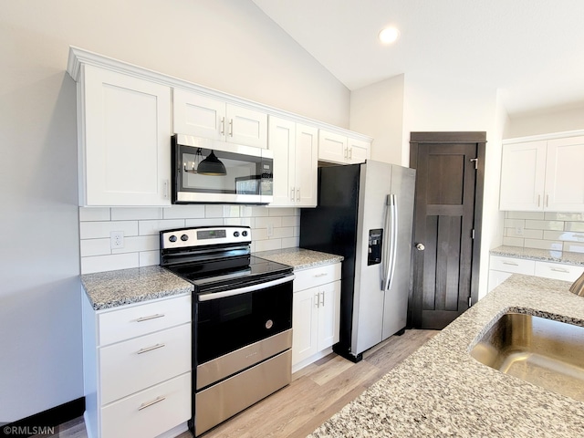 217 Bouldercrest Ave NE, Owatonna, MN 55060 - kitchen featuring appliances with stainless steel finishes, white cabinetry, light wood finished floors, backsplash, and light stone countertops