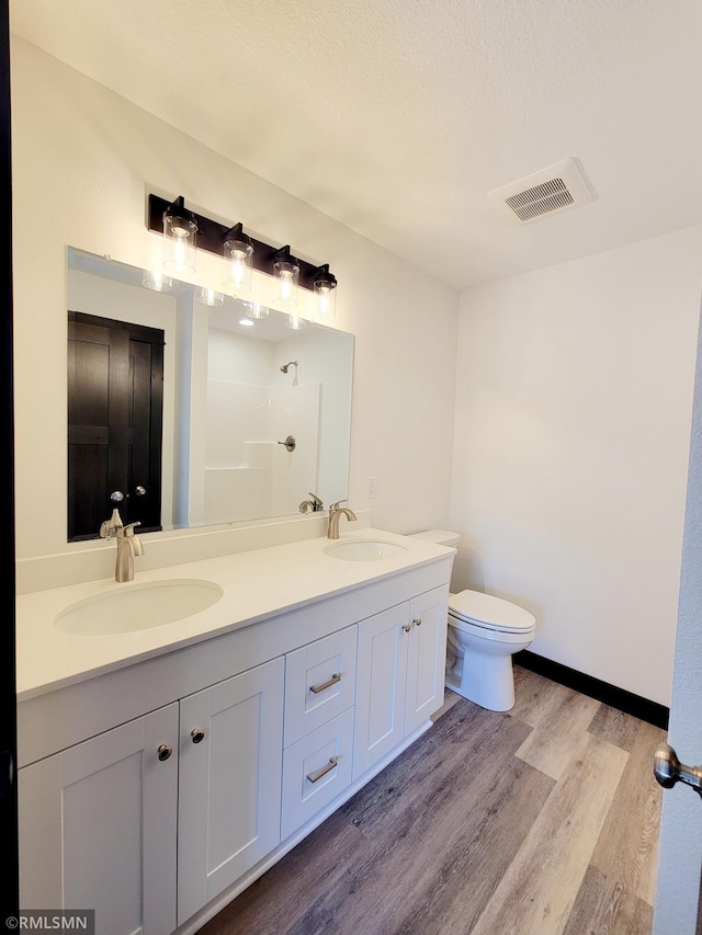 217 Bouldercrest Ave NE, Owatonna, MN 55060 - bathroom with wood finished floors, double vanity, and a shower