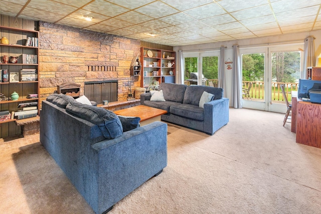 living room with light colored carpet, a fireplace, and built in shelves
