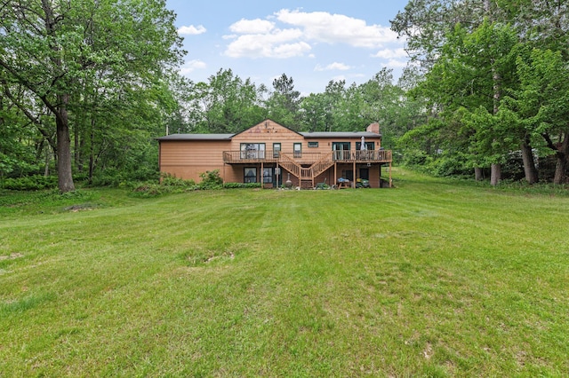 back of property with a deck, stairs, a yard, and a chimney
