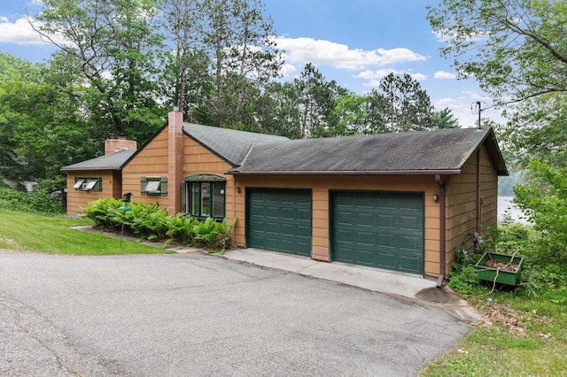 view of front of house featuring a chimney and a garage