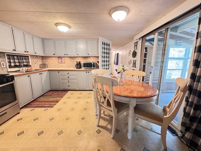 36434 145th Ave, Blueberry Twp, MN 56464 - kitchen with stainless steel appliances, light flooring, white cabinets, light countertops, and tasteful backsplash