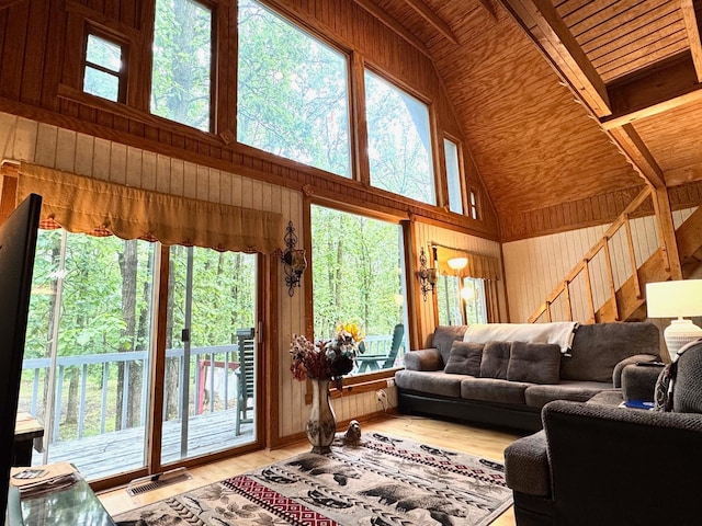 42863 270th St, Malung Twp, MN 56751 - living area featuring wooden walls, a wood ceiling with exposed beams, high vaulted ceiling, and light wood-style floors