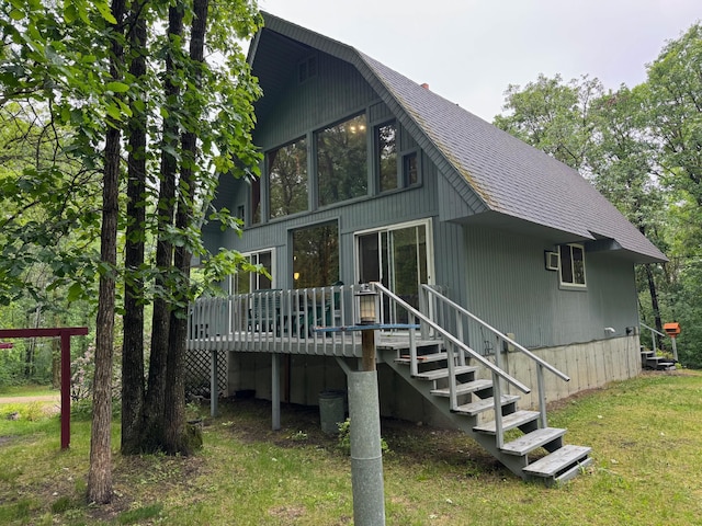42863 270th St, Malung Twp, MN 56751 - back of property with a shingled roof, a wooden deck, and a yard