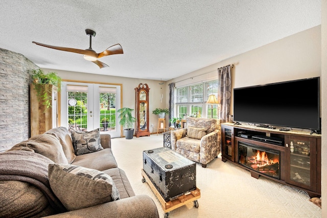 119 Morningside Dr NE, Hutchinson, MN 55350 - carpeted living room with french doors, plenty of natural light, a ceiling fan, a textured ceiling, and a glass covered fireplace
