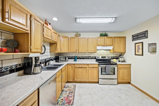 119 Morningside Dr NE, Hutchinson, MN 55350 - kitchen featuring stainless steel appliances, under cabinet range hood, tasteful backsplash, light countertops, and light tile patterned floors
