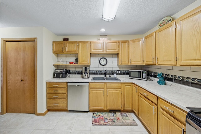 119 Morningside Dr NE, Hutchinson, MN 55350 - kitchen featuring stainless steel appliances, decorative backsplash, a textured ceiling, light countertops, and light tile patterned floors
