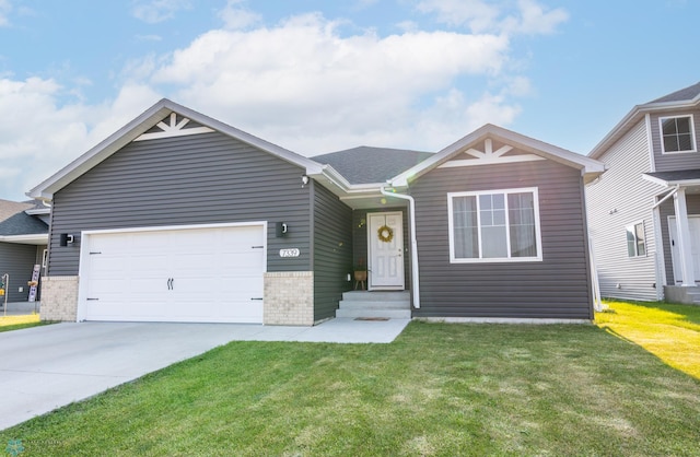 7339 21st St S, Fargo, ND 58104 - view of front of home featuring a front lawn, a garage, concrete driveway, and brick siding
