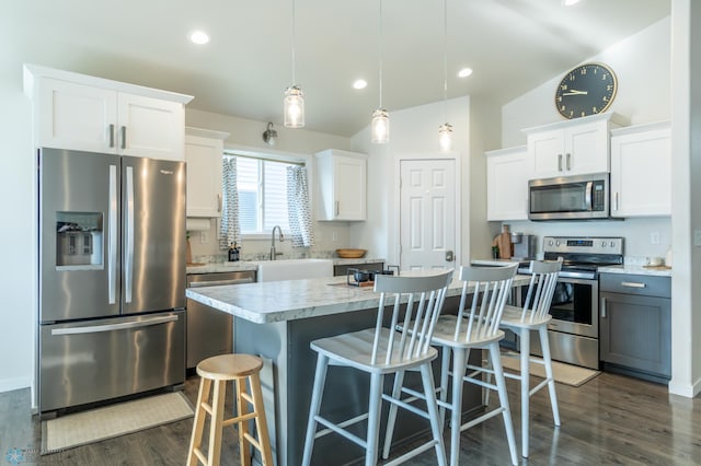 7339 21st St S, Fargo, ND 58104 - kitchen with appliances with stainless steel finishes, dark wood-style flooring, a kitchen breakfast bar, white cabinets, and recessed lighting
