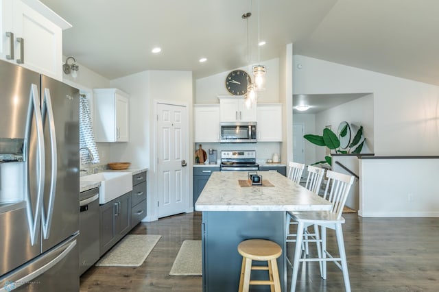 7339 21st St S, Fargo, ND 58104 - kitchen with appliances with stainless steel finishes, vaulted ceiling, light countertops, white cabinets, and dark wood finished floors