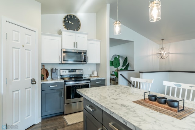 7339 21st St S, Fargo, ND 58104 - kitchen with stainless steel appliances, vaulted ceiling, white cabinets, pendant lighting, and dark wood-style floors